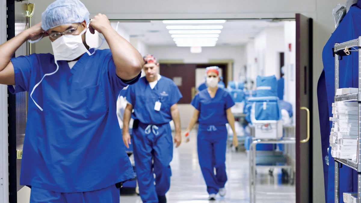 Hospital floor, person with mask and protection suit, walking, unfixing the mask, two more people in the back, 06/2015, (General, Photography, Doctor/Physician, Hospital)