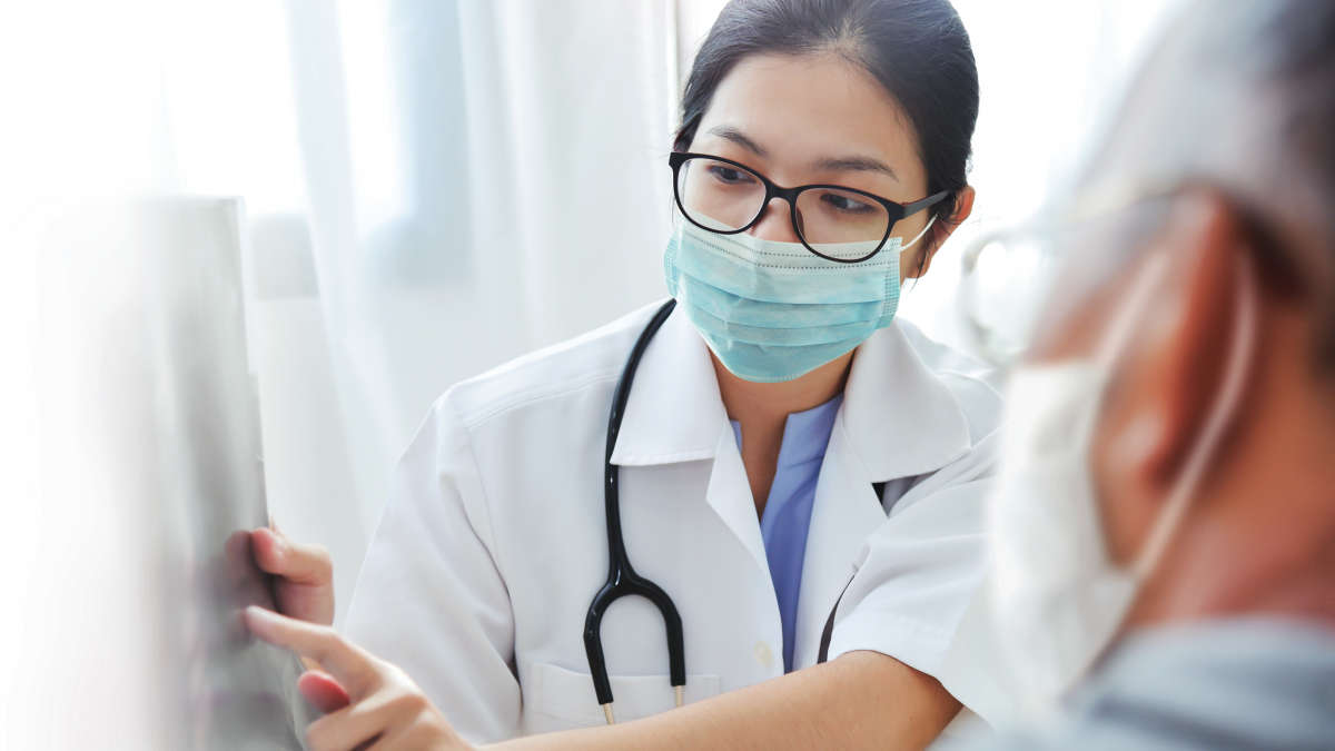 Female doctor in conversation with male older patient