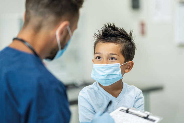 Male boy with mask talking to a doctor, Pediatrics