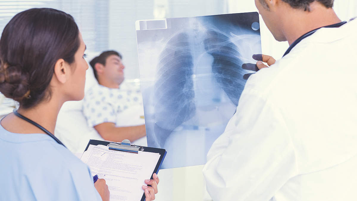 Doctors checking patients xray in hospital room