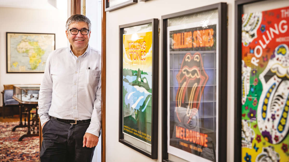NeuMoDx, Richard Dawood standing next to the rockers' posters